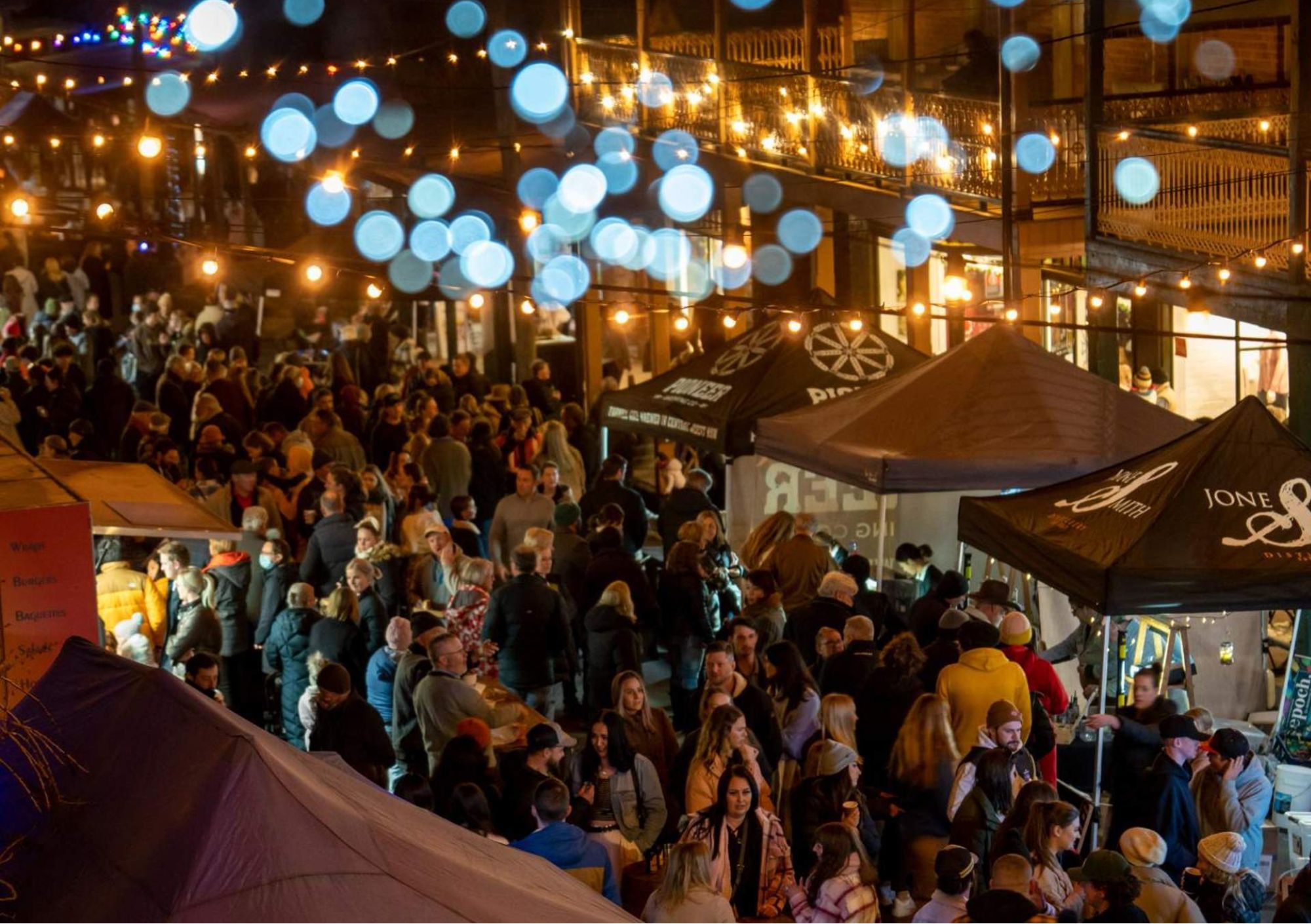 Crowds exploring night market stalls under warm lights at the Orange Region Fire Festival in Orange NSW