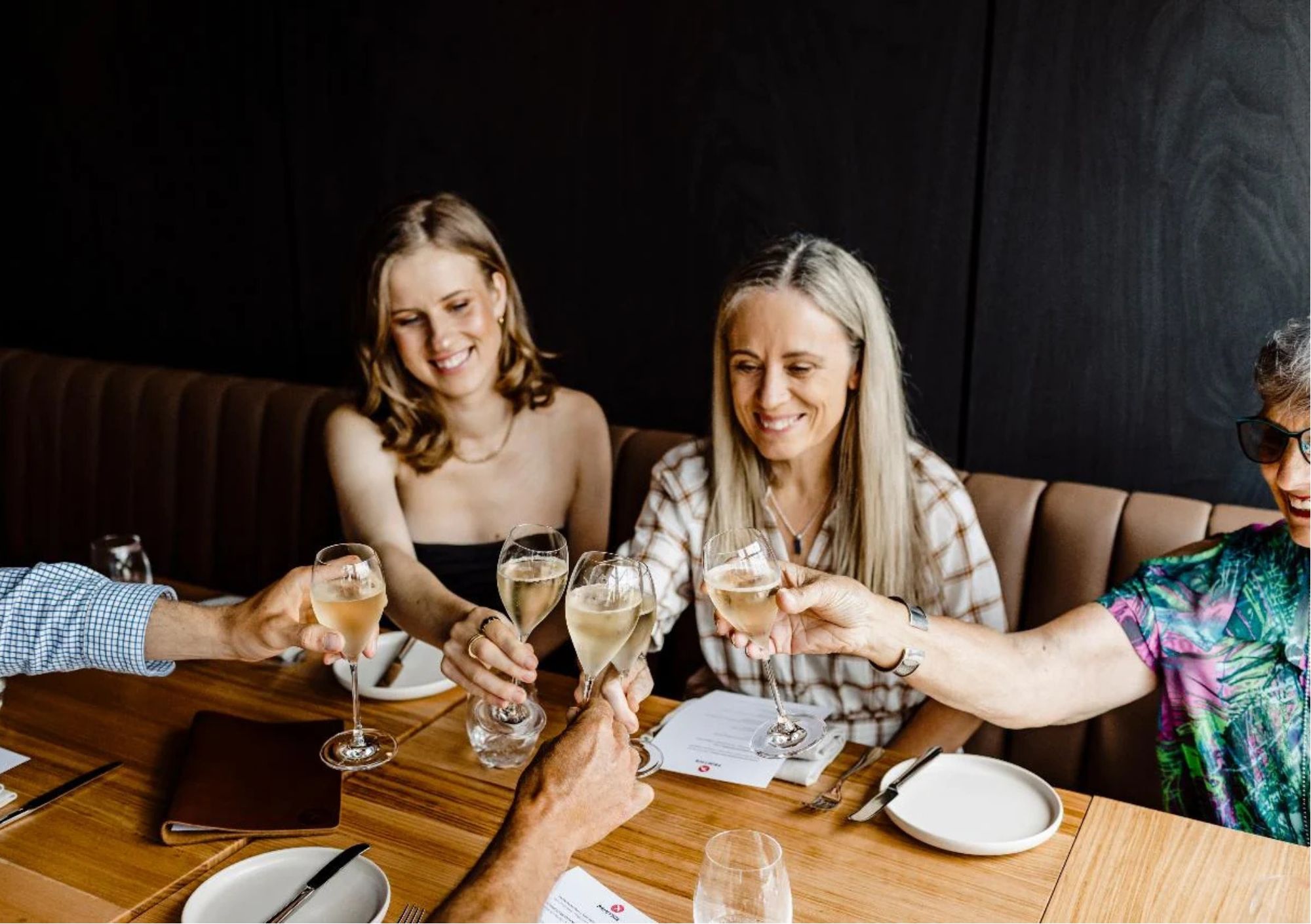 Friends enjoying sparkling wine together during a girls' weekend in Orange, NSW, celebrating with a tasting experience at a local winery restaurant.